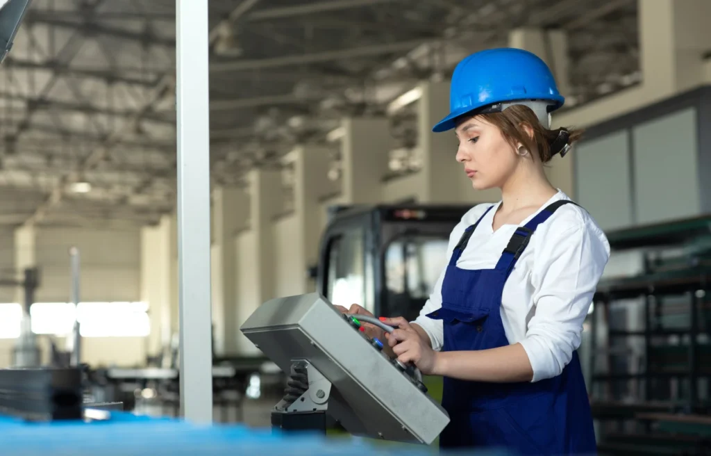 front view young attractive lady blue construction suit helmet controlling machines hangar working daytime buildings architecture construction Custom