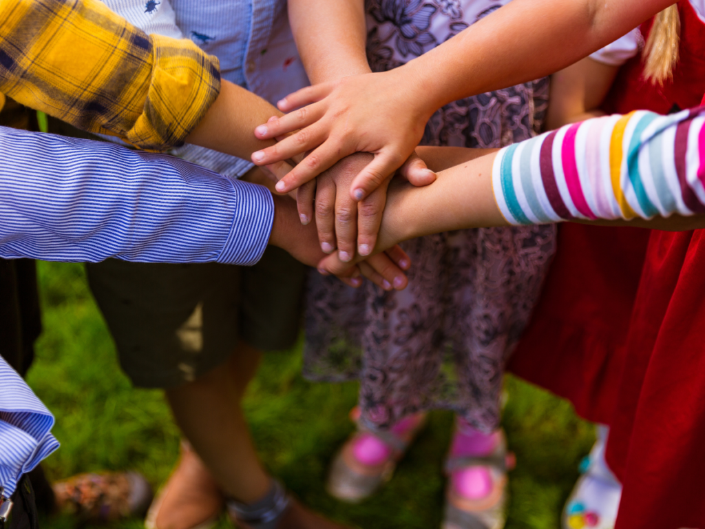 Close-up of diverse hands stacked together in support or teamwork.