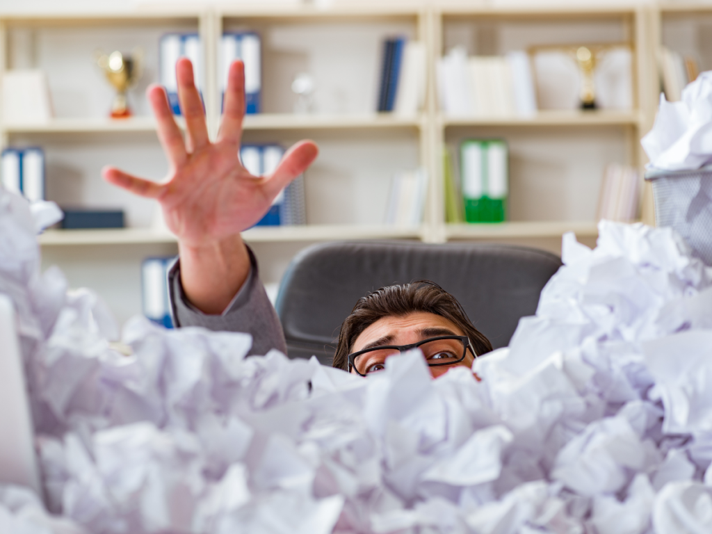 Person Drowning in Paperwork/Computer Screen. Visualizes the feeling of being overwhelmed by workload.